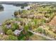 Wide aerial view of a lakefront community featuring mature trees and multiple homes with private docks at 176 Sunset Bay Dr, Troutman, NC 28166