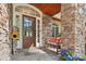 Inviting front porch with stone columns, a wooden bench, and a decorative sunflower accent at 176 Sunset Bay Dr, Troutman, NC 28166