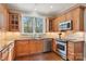 Bright kitchen featuring wooden cabinets, granite countertops and stainless steel appliances and a window looking out to the yard at 176 Sunset Bay Dr, Troutman, NC 28166