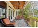 Comfortable covered porch with seating, ceiling fans, and scenic natural views at 176 Sunset Bay Dr, Troutman, NC 28166