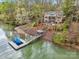 Lakefront home featuring a private dock and shoreline, surrounded by mature trees at 176 Sunset Bay Dr, Troutman, NC 28166
