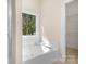 Bathroom featuring a bathtub and shower with a window for natural light at 19221 Coachmans Trce, Cornelius, NC 28031