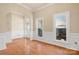 Sun-filled living room showcasing hardwood floors, white molding, and archway to the home's entry at 19221 Coachmans Trce, Cornelius, NC 28031