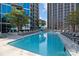 A luxurious outdoor pool area with lounge chairs and high-rise buildings in the background at 210 N Church St # 2305, Charlotte, NC 28202
