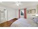 Cozy bedroom with hardwood floors, a ceiling fan, and a connected bathroom with modern fixtures at 2314 Wolfe St, Charlotte, NC 28205