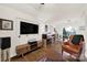 Open-concept living space showcasing hardwood floors, a large TV, and seamless flow into the dining area at 2314 Wolfe St, Charlotte, NC 28205