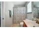 Neutral bathroom featuring a shower with patterned curtain, framed mirror, and ample counter space at 309 River Clay Rd, Fort Mill, SC 29708