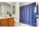 Charming bathroom with wood vanity, blue shower curtain, and a plant for added freshness at 309 River Clay Rd, Fort Mill, SC 29708