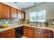 Kitchen featuring wooden cabinets, tile backsplash, light countertops, and a stainless steel sink at 309 River Clay Rd, Fort Mill, SC 29708
