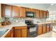 Well-lit kitchen showcasing wood cabinetry, tile backsplash, granite countertops, and modern appliances at 309 River Clay Rd, Fort Mill, SC 29708