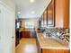 Spacious kitchen featuring wood cabinets, a tile backsplash, and modern appliances on tile floors at 309 River Clay Rd, Fort Mill, SC 29708