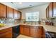 Kitchen featuring wooden cabinets, tile backsplash, light countertops, and a stainless steel sink at 309 River Clay Rd, Fort Mill, SC 29708