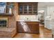 Elegant bar area with brick accent, hardwood floors, and custom cabinetry with glass doors at 3524 Johnny Cake Ln, Charlotte, NC 28226