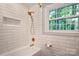Bathroom showcasing subway tile, white tub, gold fixtures, and a window for natural light at 3524 Johnny Cake Ln, Charlotte, NC 28226