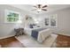 Cozy bedroom with two windows, hardwood floors, ceiling fan, and a comfortable bed at 3524 Johnny Cake Ln, Charlotte, NC 28226