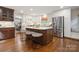 Bright kitchen featuring an island with bar seating, stainless steel refrigerator, and hardwood floors at 3524 Johnny Cake Ln, Charlotte, NC 28226