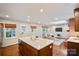 Open kitchen and living area with island seating, modern lighting, and hardwood floors at 3524 Johnny Cake Ln, Charlotte, NC 28226