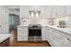 Modern white kitchen with stainless steel range, white cabinets, and hardwood flooring at 3524 Johnny Cake Ln, Charlotte, NC 28226