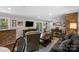 Open-concept living room featuring hardwood flooring, brick accents and an entertainment area at 3524 Johnny Cake Ln, Charlotte, NC 28226