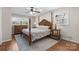 This main bedroom boasts a four-poster bed, hardwood floors, and natural light from two windows at 3524 Johnny Cake Ln, Charlotte, NC 28226