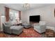 Cozy sitting area with patterned chairs, an ottoman, area rug, and a window with light filtering through at 3524 Johnny Cake Ln, Charlotte, NC 28226