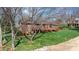 View of the back of the house featuring a large wooden deck, lush greenery, and mature trees at 3730 Club House Ne Dr, Conover, NC 28613
