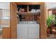 Convenient laundry closet with wood paneling containing washer, dryer, and overhead storage at 409 Cardinal Dr, Newton, NC 28658