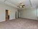 Large bedroom with tray ceiling, access to bathroom and walk-in closet, and neutral carpet flooring at 4425 Marlay Park, Indian Trail, NC 28079