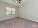 Bedroom featuring neutral carpet, two windows with blinds, and a ceiling fan at 4425 Marlay Park, Indian Trail, NC 28079