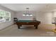 Finished basement featuring a pool table, wainscoting and overhead lighting for Gathering fun at 5125 Winding Brook Rd, Charlotte, NC 28226