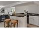 Basement bar featuring a countertop, stools, sink, mini fridge, and white cabinets for storage at 5125 Winding Brook Rd, Charlotte, NC 28226