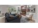 Basement living room with a brick fireplace, built in bookshelves, and comfortable furniture at 5125 Winding Brook Rd, Charlotte, NC 28226