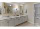 Updated bathroom featuring a double vanity with framed mirrors, neutral cabinets, and tiled floors at 5125 Winding Brook Rd, Charlotte, NC 28226
