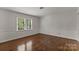 A minimalist bedroom with hardwood floors and natural light creates a relaxing retreat at 5125 Winding Brook Rd, Charlotte, NC 28226
