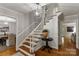 Bright foyer with beautiful hardwood floors, staircase, and stylish light fixture at 5125 Winding Brook Rd, Charlotte, NC 28226