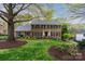 Charming brick two-story home with manicured lawn and mature trees providing great curb appeal at 5125 Winding Brook Rd, Charlotte, NC 28226