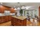 Well-lit kitchen with wood cabinets, granite countertops, and island with a breakfast nook at 5125 Winding Brook Rd, Charlotte, NC 28226