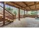 Covered brick patio with wooden beams, outdoor seating, and access to the backyard at 5125 Winding Brook Rd, Charlotte, NC 28226
