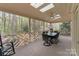 Relaxing screened-in porch with an outdoor dining area and ceiling fans at 5125 Winding Brook Rd, Charlotte, NC 28226