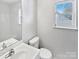Bright bathroom featuring a modern vanity, commode, and tub/shower combo with a window view at 5407 Windy Valley Dr, Charlotte, NC 28208