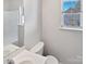 Bathroom featuring a white sink, toilet, and a bright window at 5407 Windy Valley Dr, Charlotte, NC 28208