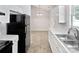 Well-lit kitchen featuring white cabinets, stainless steel sink, modern appliances, and dining area at 5407 Windy Valley Dr, Charlotte, NC 28208