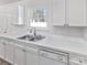 Bright kitchen featuring white cabinets, stainless steel sink, white countertops, and a window at 5407 Windy Valley Dr, Charlotte, NC 28208