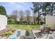Backyard with patio seating, a manicured lawn, and mature trees, perfect for outdoor gatherings at 5622 Dartington Dr, Indian Land, SC 29707