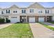 Exterior elevation of the townhome showcasing a well-manicured lawn, attached garage, and brick facade at 5622 Dartington Dr, Indian Land, SC 29707