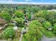 Expansive aerial view of a lush neighborhood with tree-lined streets and the city skyline in the distance at 5876 Wedgewood Dr, Charlotte, NC 28210