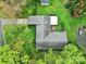 Aerial view of house with back patio, lush green yard, and large roof, surrounded by green space and trees at 5876 Wedgewood Dr, Charlotte, NC 28210