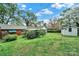 Spacious backyard with a shed, beautiful flowering trees, and lush green lawn, perfect for outdoor activities at 5876 Wedgewood Dr, Charlotte, NC 28210