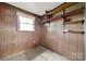 This bedroom features wood paneling, built in shelving, a carpet floor and a window to let in natural light at 5876 Wedgewood Dr, Charlotte, NC 28210