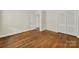 This bedroom features hardwood floors, white walls, base molding, a closet and an open doorway at 5876 Wedgewood Dr, Charlotte, NC 28210